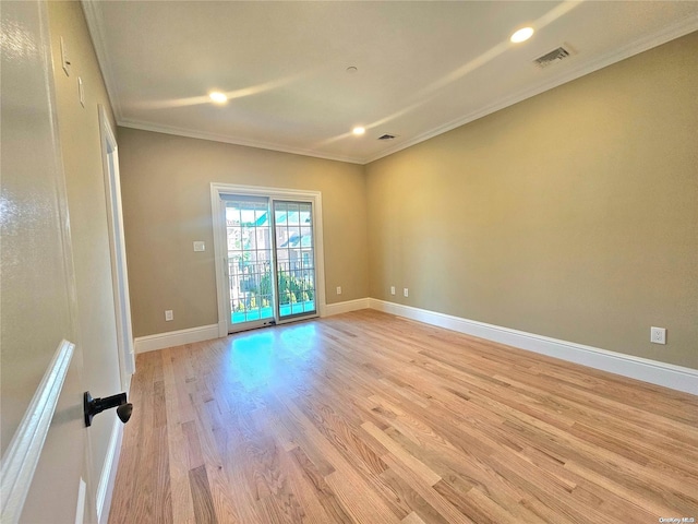 spare room with light hardwood / wood-style floors and crown molding