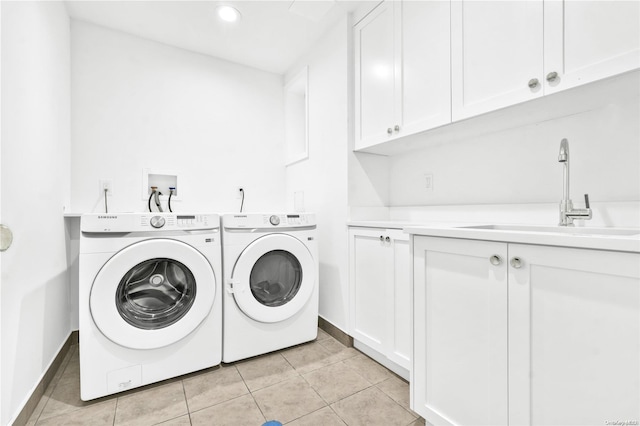 washroom featuring washer and clothes dryer, sink, light tile patterned floors, and cabinets