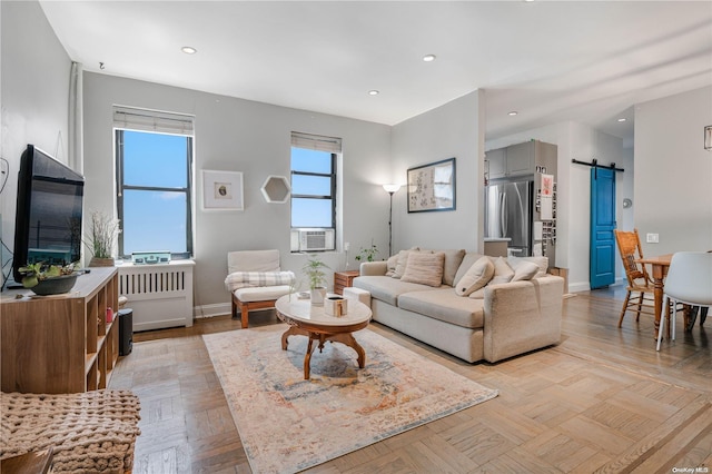 living room featuring a barn door, cooling unit, and light parquet flooring