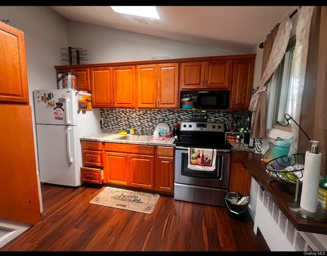 kitchen with dark wood-type flooring, white fridge, lofted ceiling, decorative backsplash, and stainless steel range with electric cooktop