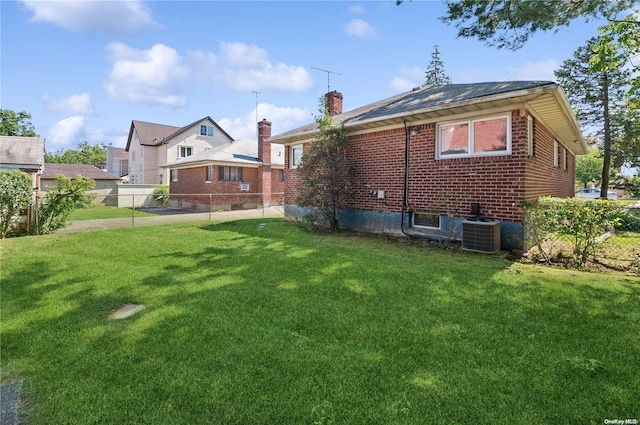 back of house with a lawn and central AC