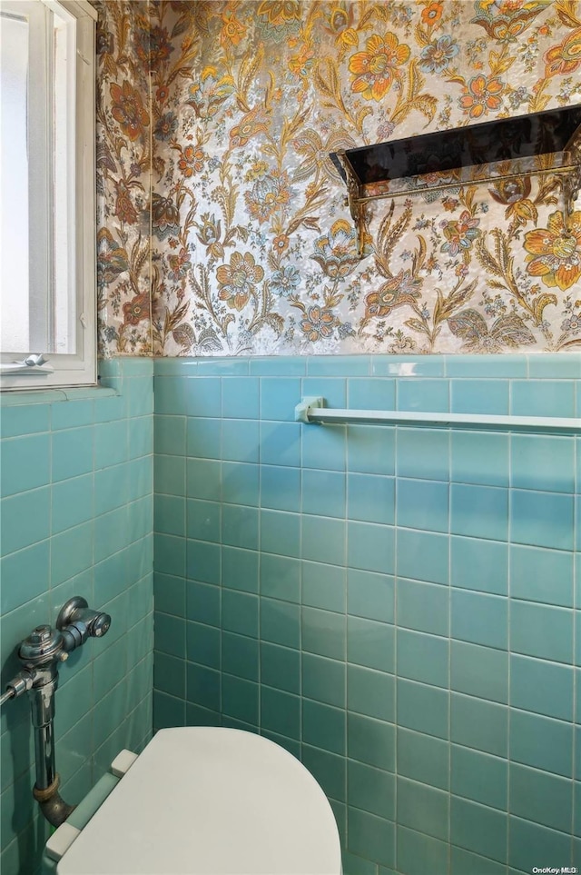 bathroom with toilet and tile walls