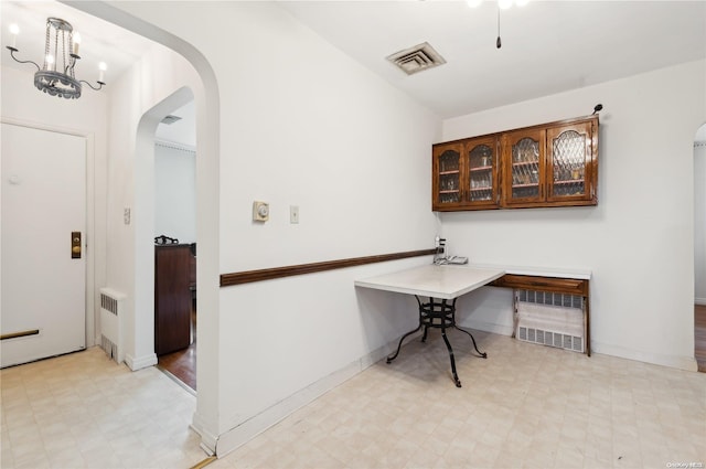 home office featuring radiator and a notable chandelier