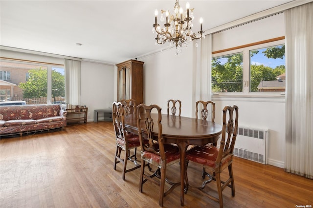 dining area featuring a chandelier, radiator, hardwood / wood-style flooring, and a wealth of natural light