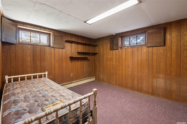 unfurnished bedroom featuring carpet, a baseboard heating unit, and wood walls