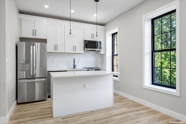 kitchen featuring white cabinets, pendant lighting, a center island, and stainless steel appliances