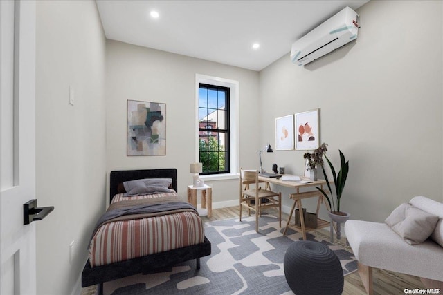 bedroom featuring a wall mounted air conditioner and light hardwood / wood-style flooring