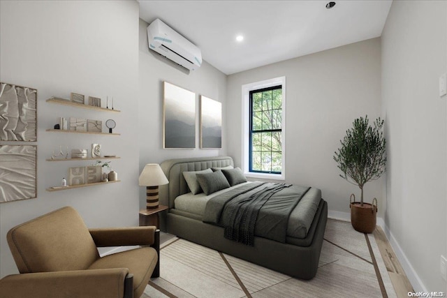 bedroom featuring a wall mounted air conditioner and light hardwood / wood-style flooring