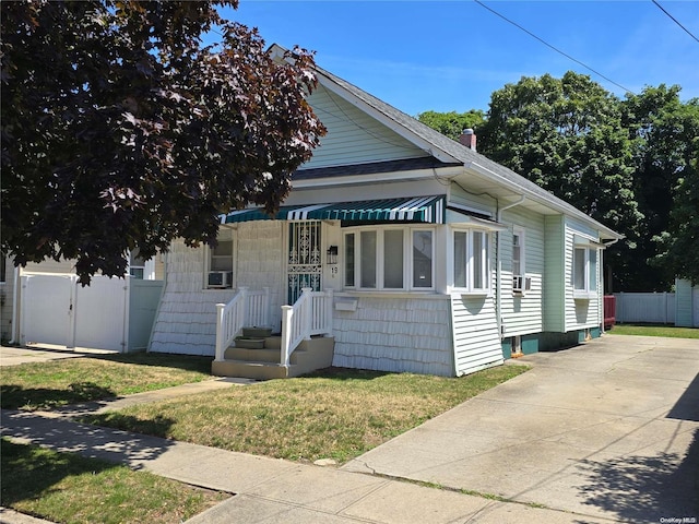 view of front of house with cooling unit and a front lawn