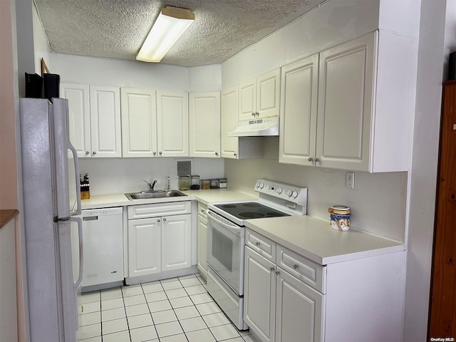 kitchen with white appliances, sink, light tile patterned floors, a textured ceiling, and white cabinetry