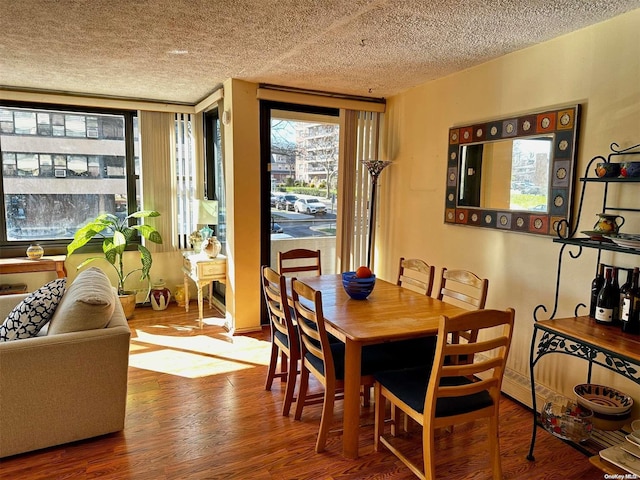 dining area with hardwood / wood-style floors and a textured ceiling