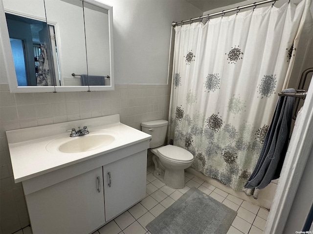 bathroom featuring tile patterned flooring, vanity, tile walls, and toilet