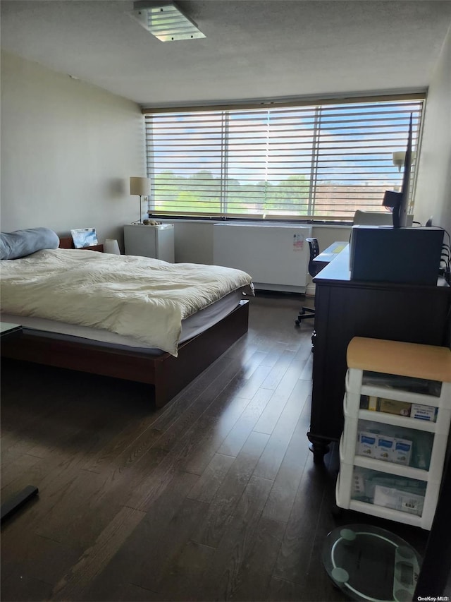 bedroom with dark hardwood / wood-style flooring and multiple windows