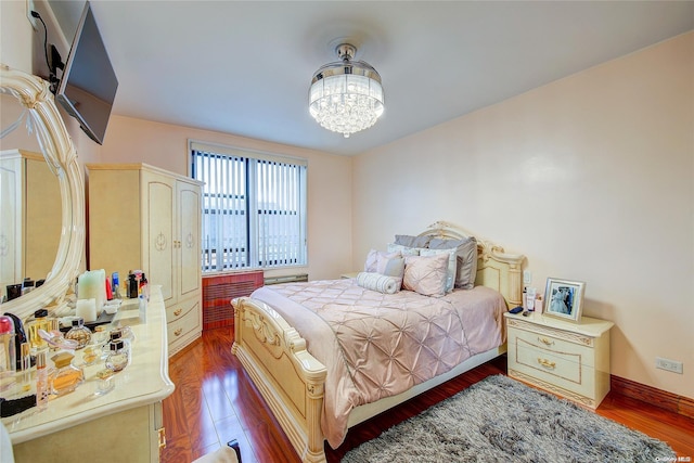 bedroom with dark wood-type flooring and a chandelier