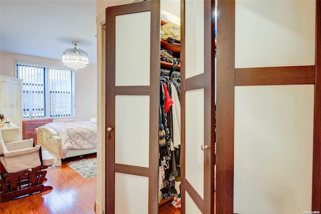 hall featuring hardwood / wood-style floors and an inviting chandelier