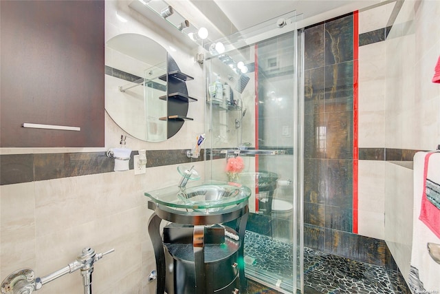 bathroom featuring an enclosed shower, vanity, and tile walls