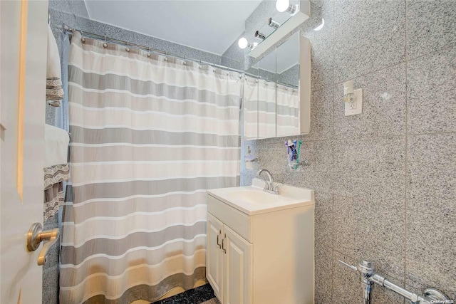 bathroom with vanity, tile walls, and tasteful backsplash