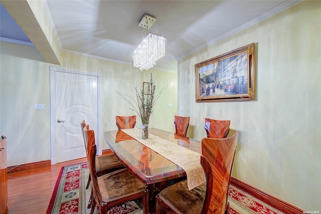 dining room with an inviting chandelier, wood-type flooring, and ornamental molding