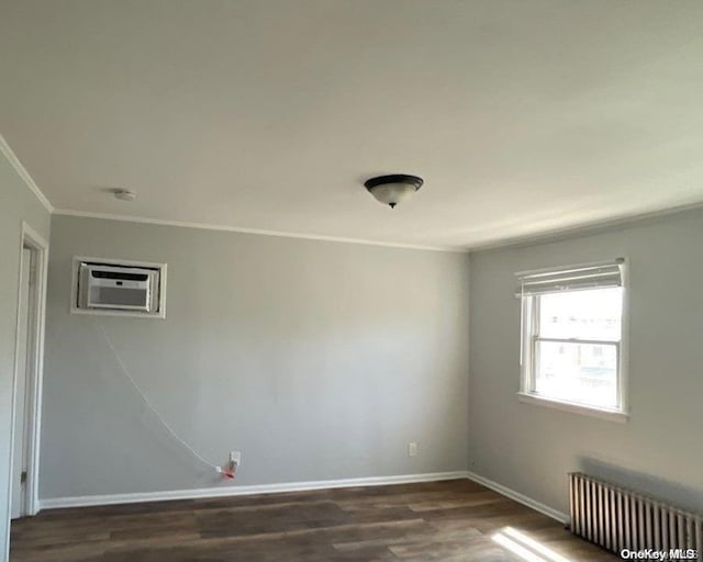 spare room featuring radiator, a wall mounted AC, dark hardwood / wood-style floors, and ornamental molding