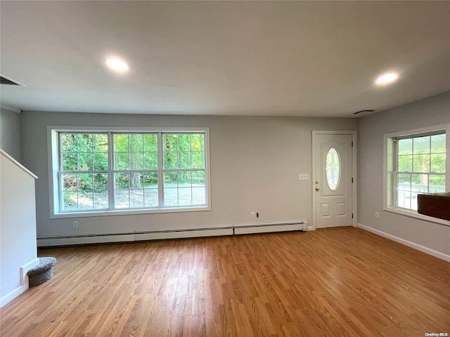 entryway featuring light hardwood / wood-style flooring, a wealth of natural light, and a baseboard radiator