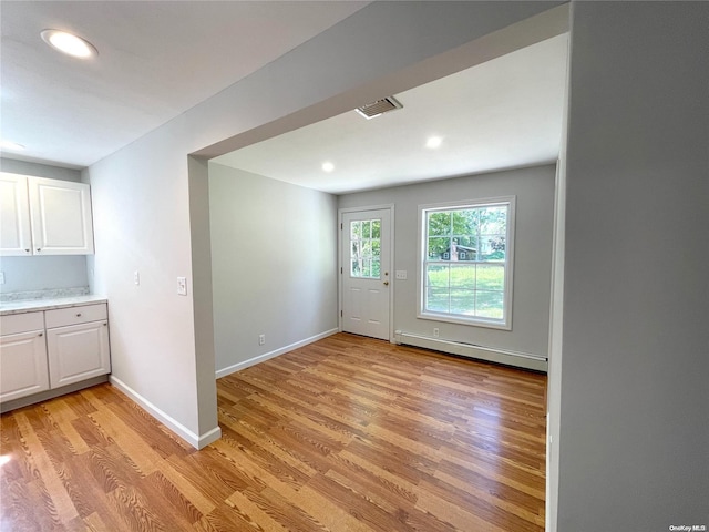 interior space with light wood-type flooring and baseboard heating