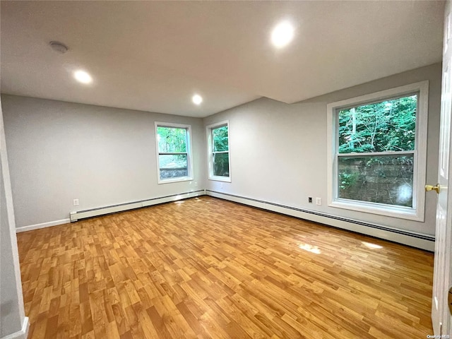 empty room with light hardwood / wood-style floors and baseboard heating