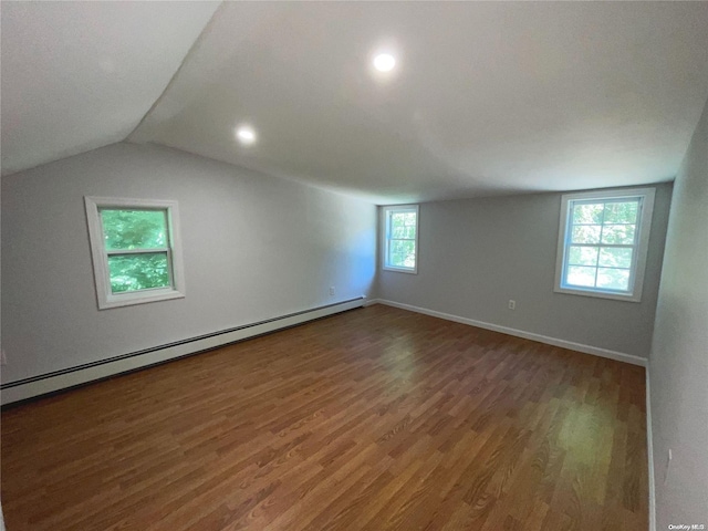 bonus room with vaulted ceiling, a baseboard radiator, a healthy amount of sunlight, and dark hardwood / wood-style floors