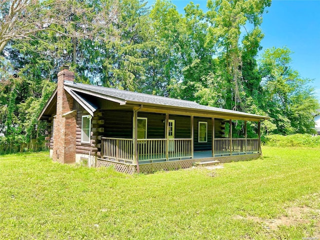 cabin featuring covered porch and a front yard