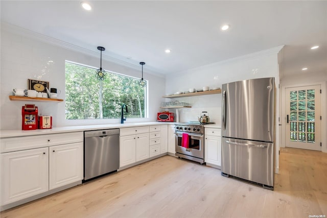 kitchen with white cabinets, decorative light fixtures, light wood-type flooring, and appliances with stainless steel finishes