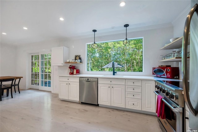 kitchen featuring plenty of natural light, light hardwood / wood-style floors, white cabinetry, and appliances with stainless steel finishes