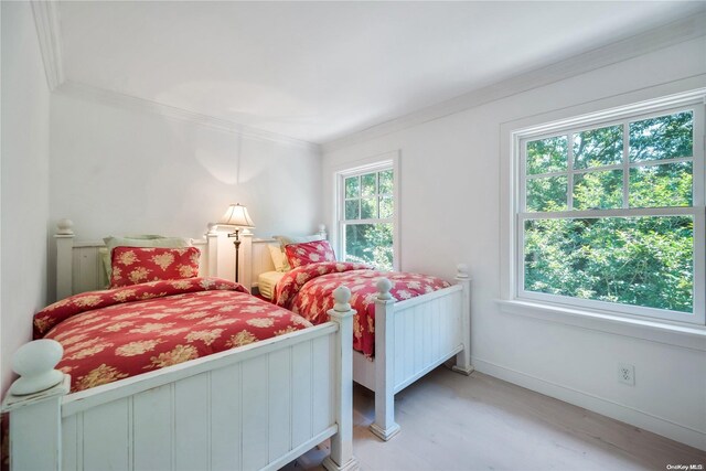 bedroom with crown molding and light wood-type flooring