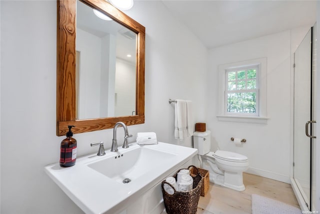 bathroom with toilet, sink, an enclosed shower, and hardwood / wood-style flooring