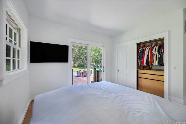 bedroom with hardwood / wood-style floors, access to exterior, and a closet