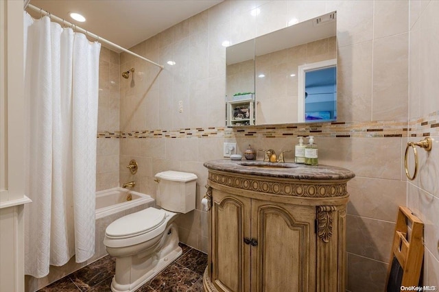 full bathroom featuring shower / bath combination with curtain, vanity, toilet, and tile walls