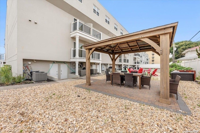 view of patio / terrace with a gazebo, cooling unit, and a balcony