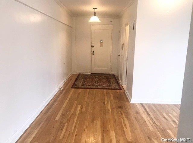 corridor featuring hardwood / wood-style floors and crown molding