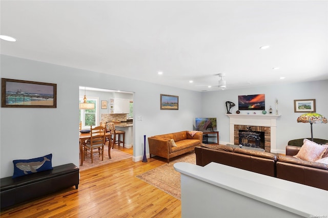 living room with ceiling fan and light hardwood / wood-style flooring