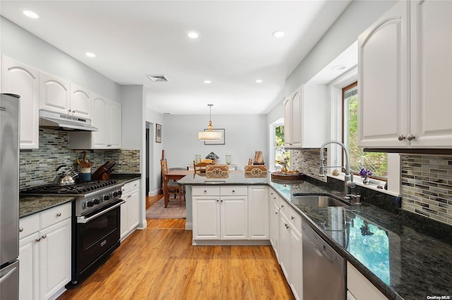 kitchen with sink, pendant lighting, light hardwood / wood-style floors, white cabinets, and appliances with stainless steel finishes