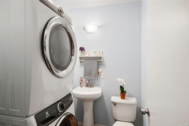 bathroom with toilet and stacked washer and clothes dryer