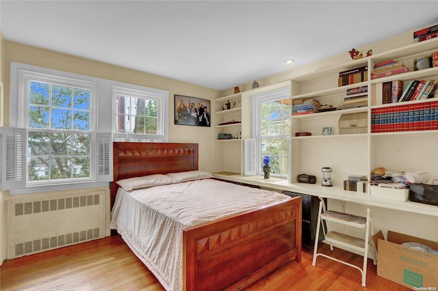 bedroom with light hardwood / wood-style floors and radiator