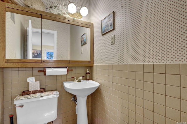 bathroom with toilet and tile walls