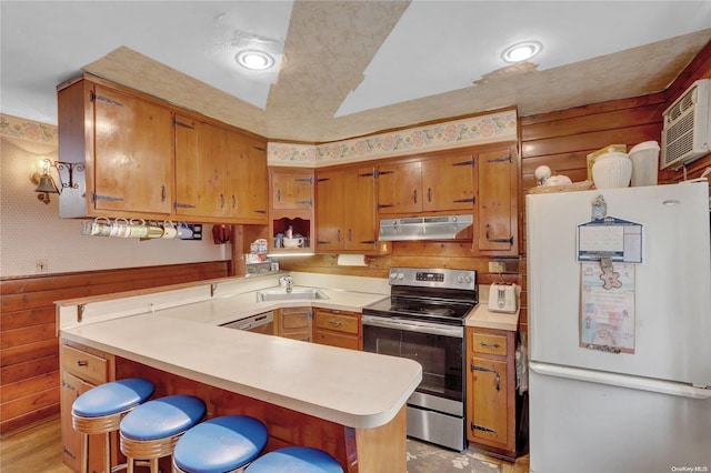 kitchen with kitchen peninsula, a breakfast bar, sink, electric stove, and white fridge