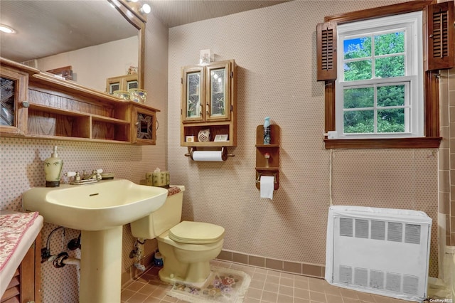 bathroom featuring tile patterned floors, heating unit, and toilet