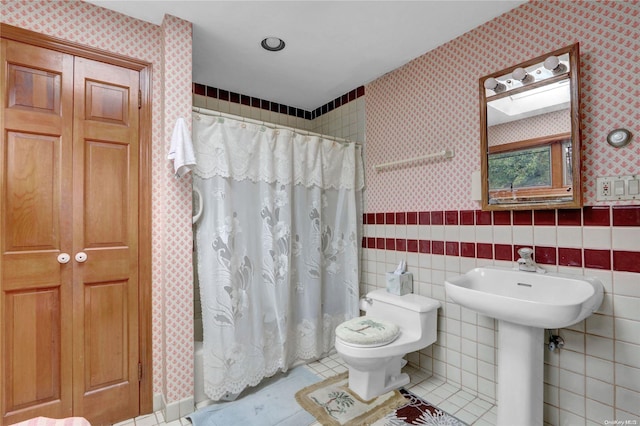 bathroom with tile patterned floors, tile walls, and toilet