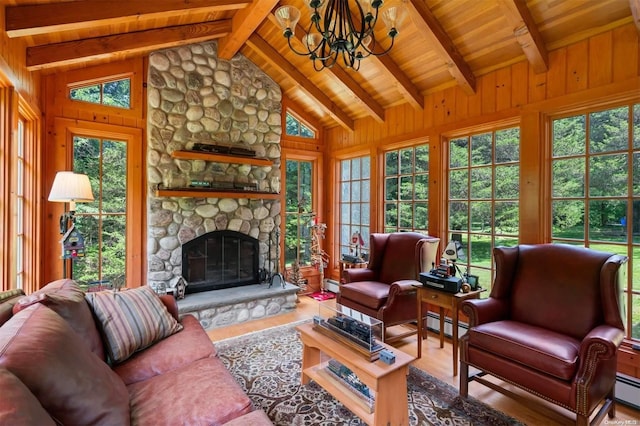 living room featuring a chandelier, wood-type flooring, a stone fireplace, and a baseboard heating unit