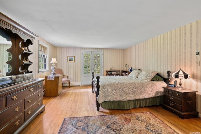 bedroom with multiple windows, light hardwood / wood-style flooring, and a baseboard radiator