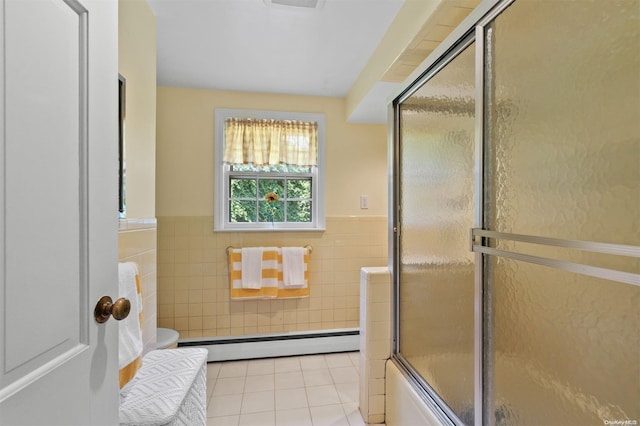 bathroom featuring combined bath / shower with glass door, tile patterned flooring, toilet, tile walls, and a baseboard radiator