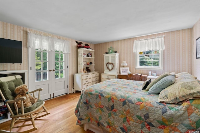 bedroom featuring light wood-type flooring, french doors, and multiple windows