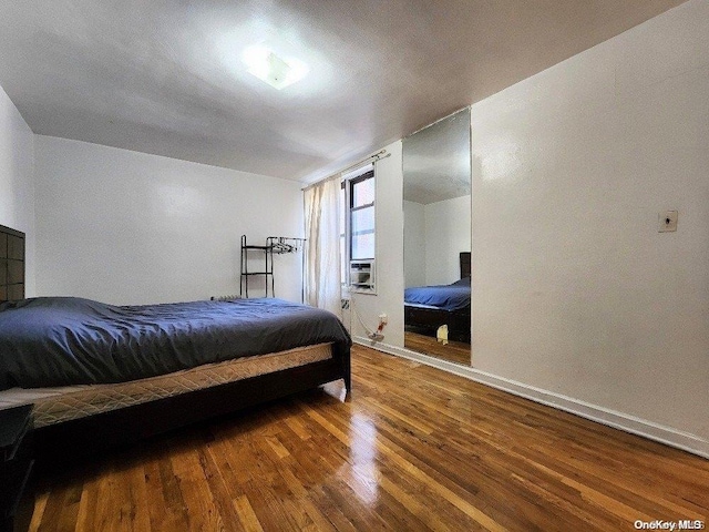 bedroom with dark hardwood / wood-style flooring and cooling unit