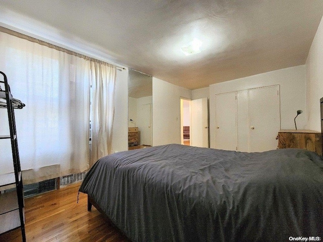 bedroom with hardwood / wood-style floors and a closet